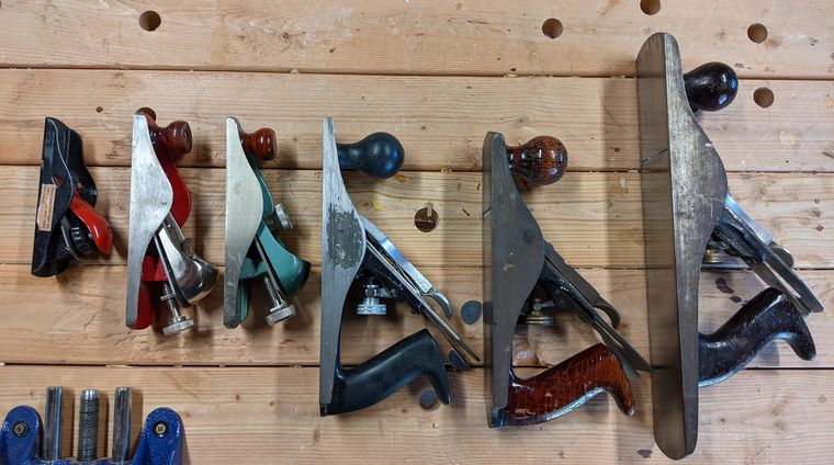 wood planes lined up on workbench